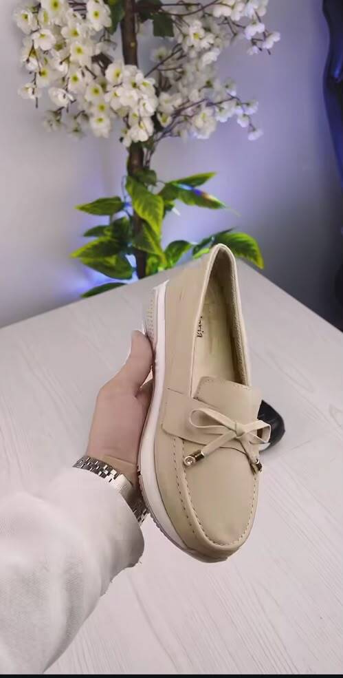 ActoStore beige signature loafer held in hand